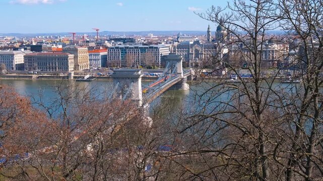 Chained secheni bridge. A beautiful ancient Secheni chained bridge over calm blue river water against famous Budapest buildings in the sun light.