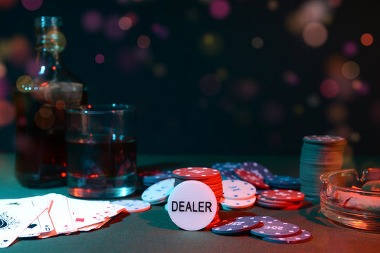 Poker chips and playing cards on dark background