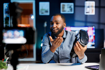 Smiling tech content creator filming technology review of newly released VR glasses, unboxing them...