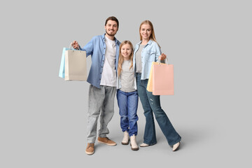 Obraz premium Happy family in stylish denim clothes with shopping bags on grey background
