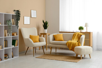 Interior of living room with comfortable sofa, armchair, bookcase and yellow plaid