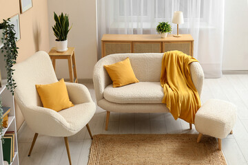 Interior of living room with comfortable sofa, armchair, bookcase and yellow plaid