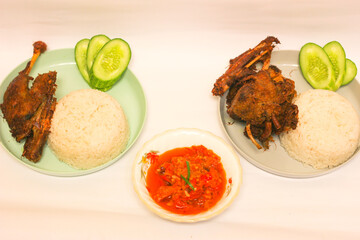  A serving of white rice accompanied by grilled chicken and a rich tomato sauce, offering a delicious and satisfying meal.