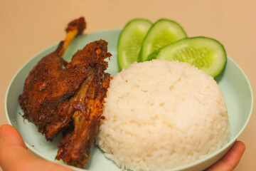  A serving of white rice accompanied by grilled chicken and a rich tomato sauce, offering a delicious and satisfying meal.