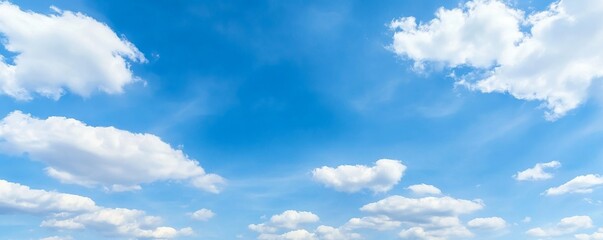 Obraz premium Panoramic banner of a blue sky with clouds and ample copy space, ideal for backgrounds and design use.