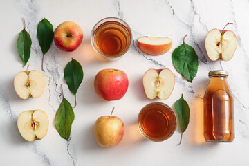 Bottle and glasses of fresh apple juice on white background