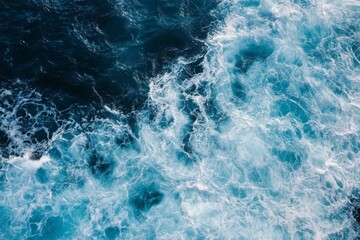 Fototapeta premium Top view of blue ocean water with intricate wave textures and water splashes, creating an abstract background of the sea surface, showcasing the dynamic movement and vibrant blue tones of the ocean.