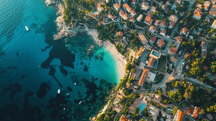 Stunning aerial view of a serene beach surrounded by vibrant buildings and clear turquoise water, perfect for vacation inspiration.