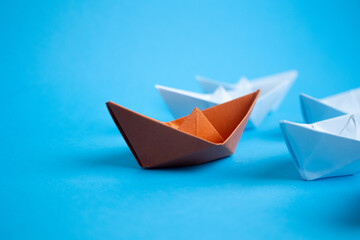 leader orange paper ship and white paper ships following, For influencer or leadership concept.