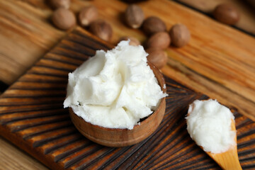 Bowl with shea butter on wooden table, closeup
