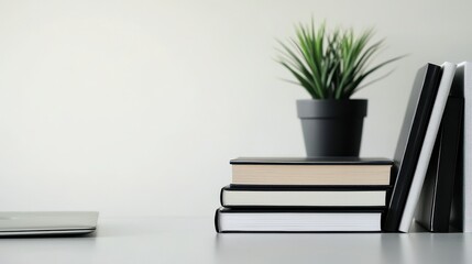 Stack of Books and Laptop on Desk with Minimalist Design