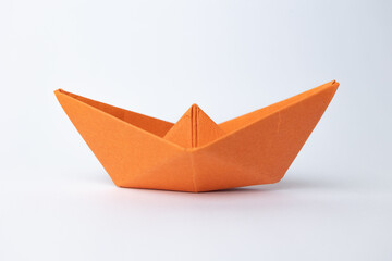 orange paper ship on white background ,concept for leadership, teamwork and winning success.