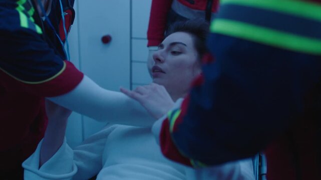 Paramedics giving first aid to the female patient inside the ambulance