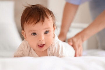 Cute little baby getting massage on bed, closeup