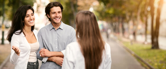 Married Couple Meeting Single Female Friend Walking Outdoor In Park. Friendship With Ex-Boyfriend Concept. Selective Focus