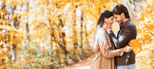 Romantic couple hugging and talking about love, dating in autumn park, copy space