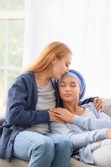 Young woman after chemotherapy with her mother hugging at home