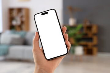 Woman with blank mobile phone at home, closeup