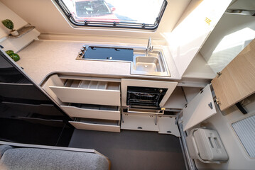 Interior with,tables,refrigerator,kitchen corners,ceiling ligthning,couches,living space in modern Slovenian camper van Adria.