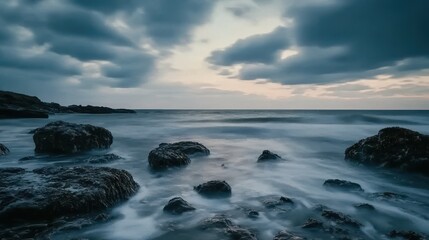 Obraz premium Misty Coastal Landscape with Dramatic Sky and Smooth Water - Long Exposure Photography.