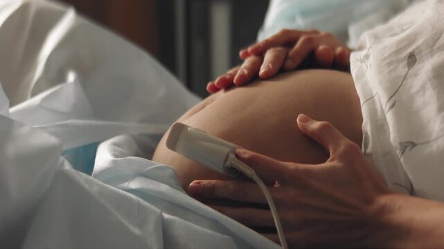 Pregnant mother at hospital holding her stomach right before giving birth