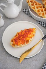 croffle snack food with various toppings, gray background