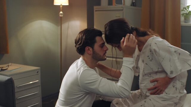 Man helping his wife while she is in pain