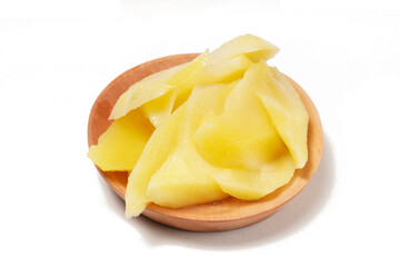 Young mango kickshaw, made from thinly sliced tangy yellow mango, placed on a wooden dish, photographed with a white background.