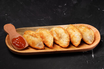 Fried stuffed Cireng, a traditional Indonesian snack filled with seasoned beef fat or jando, perfect with chili sauce dip, photographed against a dark background.
