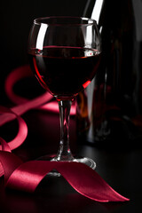 bottle, set against a vibrant red background.

A bottle of red wine and a glass on a striking red backdrop.