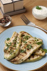 Tasty grilled courgette slices served on wooden table