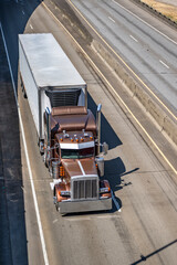 Brown classic stylish big rig semi truck tractor with chrome accessories and additional side and...