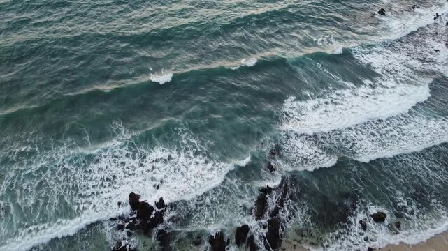 Aerial view of waves on Sunset Beach in Koh Kradan on windy day at rainy season; power of nature, wild conceps; waves crashing in slow motion against the rocks on the island; Trang, Thailand
