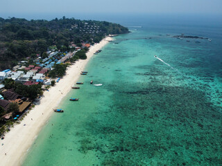 Aerial view of the Long Beach on Koh Phi Phi Don and the Blacktip Reef Shark point; beautiful landscape of white sand, turquoise water, coral reef, dense vegetation and blue sky; Krabi, Thailand