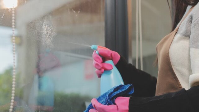 glass cleaner on a sheet of Cleaning glass window with a cloth special rag blue. close up hand