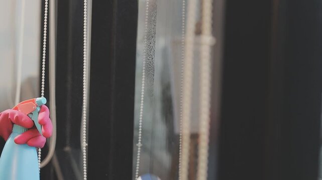 glass cleaner on a sheet of Cleaning glass window with a cloth special rag blue. close up hand