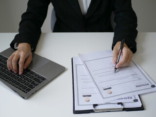 Business woman employer holds resume and talks with job applicant for job interview about her career and personal history in company, recruitment concept