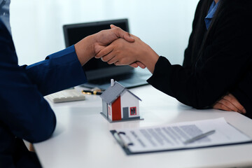 Estate agent shaking hands with customer after contract signature