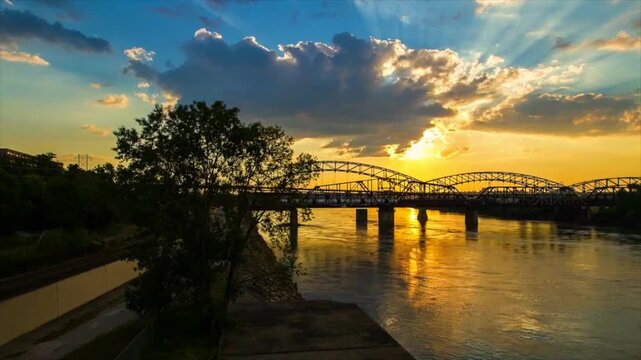 Time Lapse Lockdown Shot Of Silhouette Buck O'Neil Bridge Over Flowy River During Sunset - Kansas City, Missouri