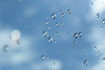 water drop on mirror with blue sky and white cloud background