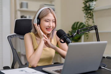 Asian young audio DJ woman talking on microphone to broadcasting.