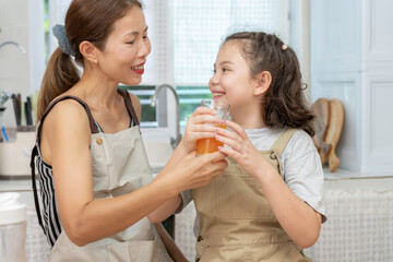 activities together during the holidays. Parents and children are having a meal together, Mather prepare orange juice for daughter  on morning, enjoy, weekend, vacant, family time, happy.