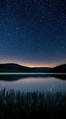 A tranquil night scene with a starry sky reflected in a calm lake surrounded by hills, perfect for nature lovers and serene landscapes.
