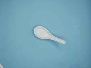 Porcelain spoon on blue background.