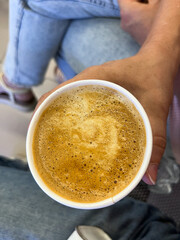 latte coffee in a cup with foam in hand