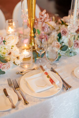 Beautiful table in a restaurant decorated with flowers and candles. Plate and cutlery with chopsticks. Beautifully set table waiting for guests in a restaurant