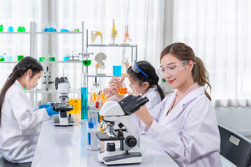 female scientist as a mentor is teaching the student, kids studying science in laboratory