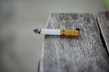 closeup of a cigarette on the edge of a wooden table