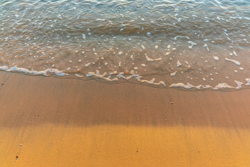 Soft wave of the sea on the sandy beach.
