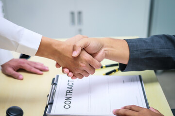 A lawyer is seated at a desk in an office, reviewing and signing legal documents. The scene captures a professional setting focused on contracts, finance,  providing legal advice to clients.